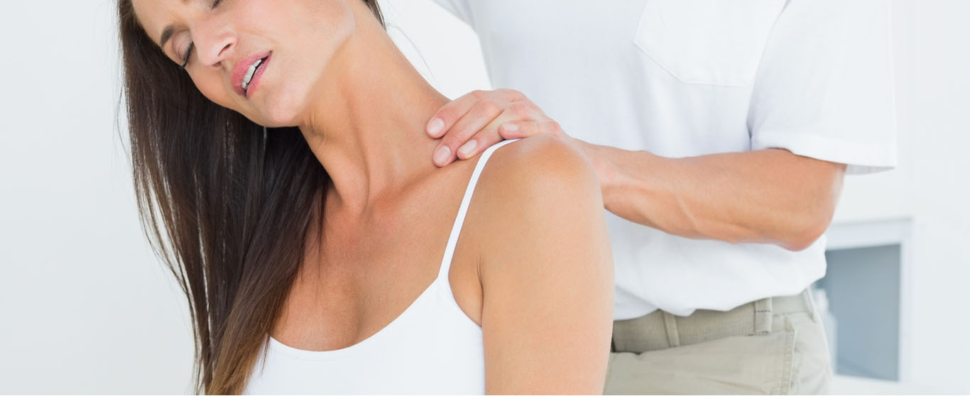 Clinician examining a patient’s neck and shoulder