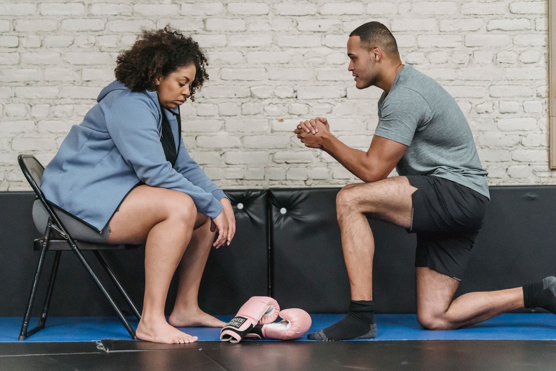 A trainer supporting a woman during a guided movement session